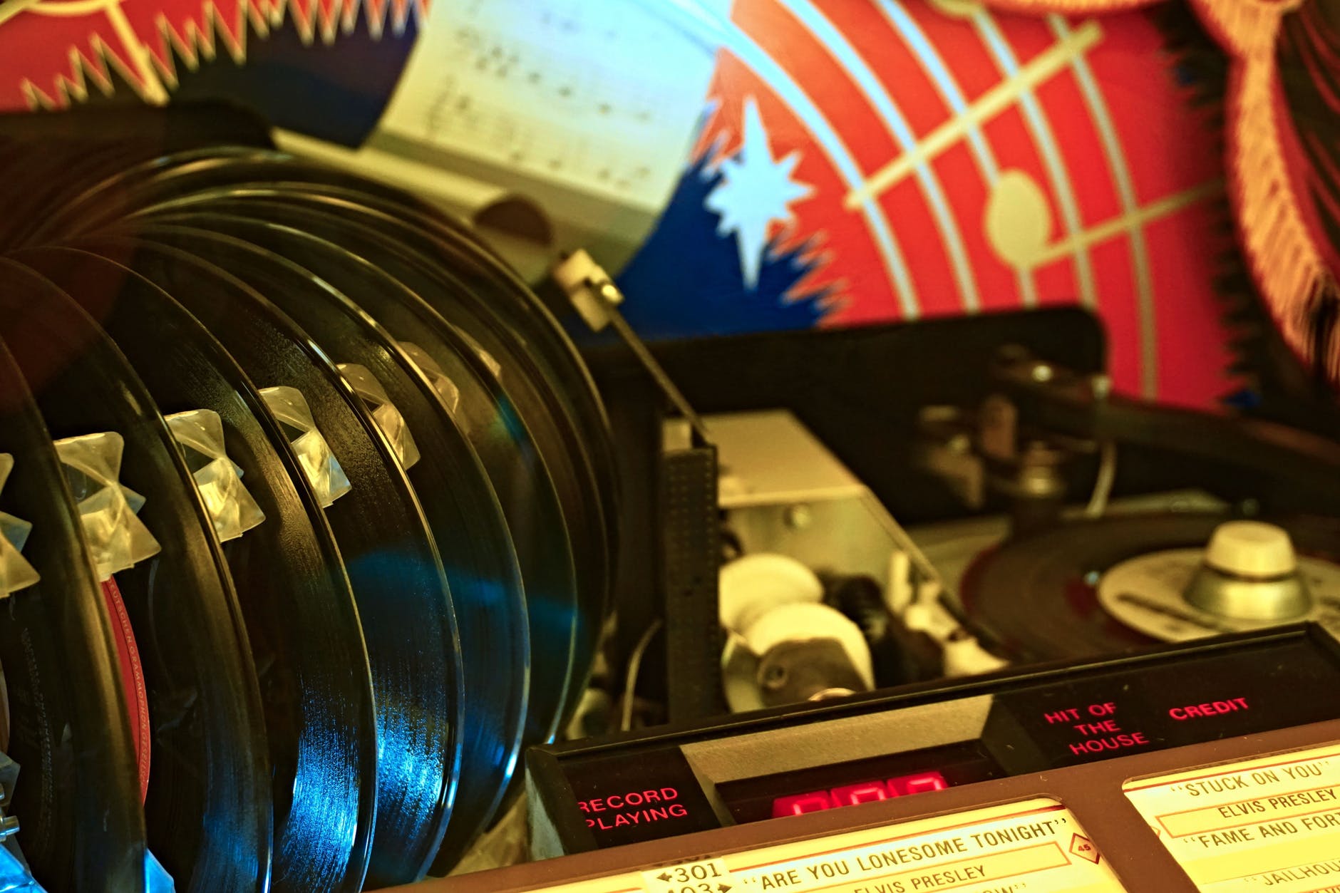 Vintage jukebox and vinyl records with colorful background.