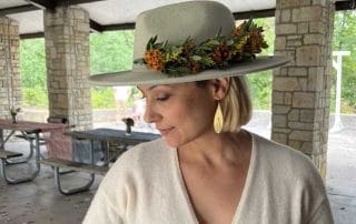 a woman shows off her handmade flower crown at a country club event